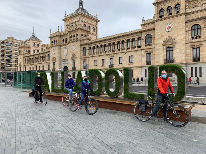 Varios ciclistas pasan ante las letras naturales de Valladolid.